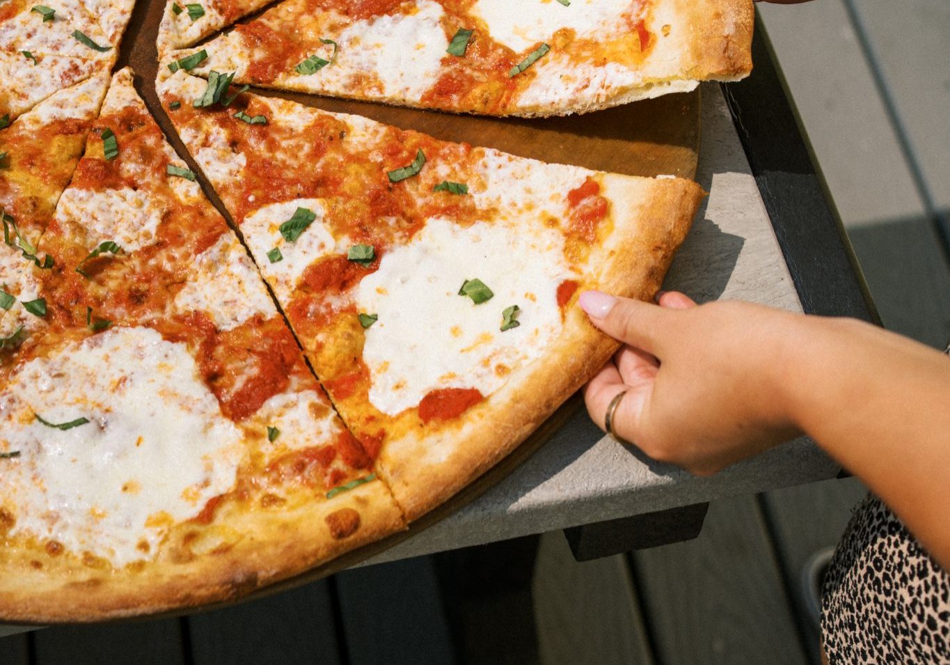 Customer taking a slice of Boardwalk pizza