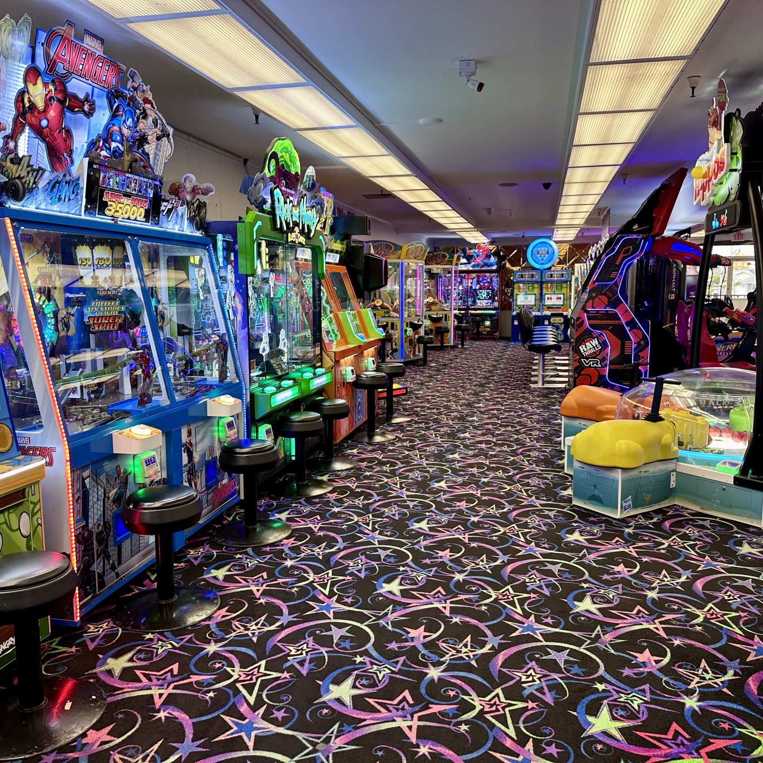 A row of arcade games in a spacious room.