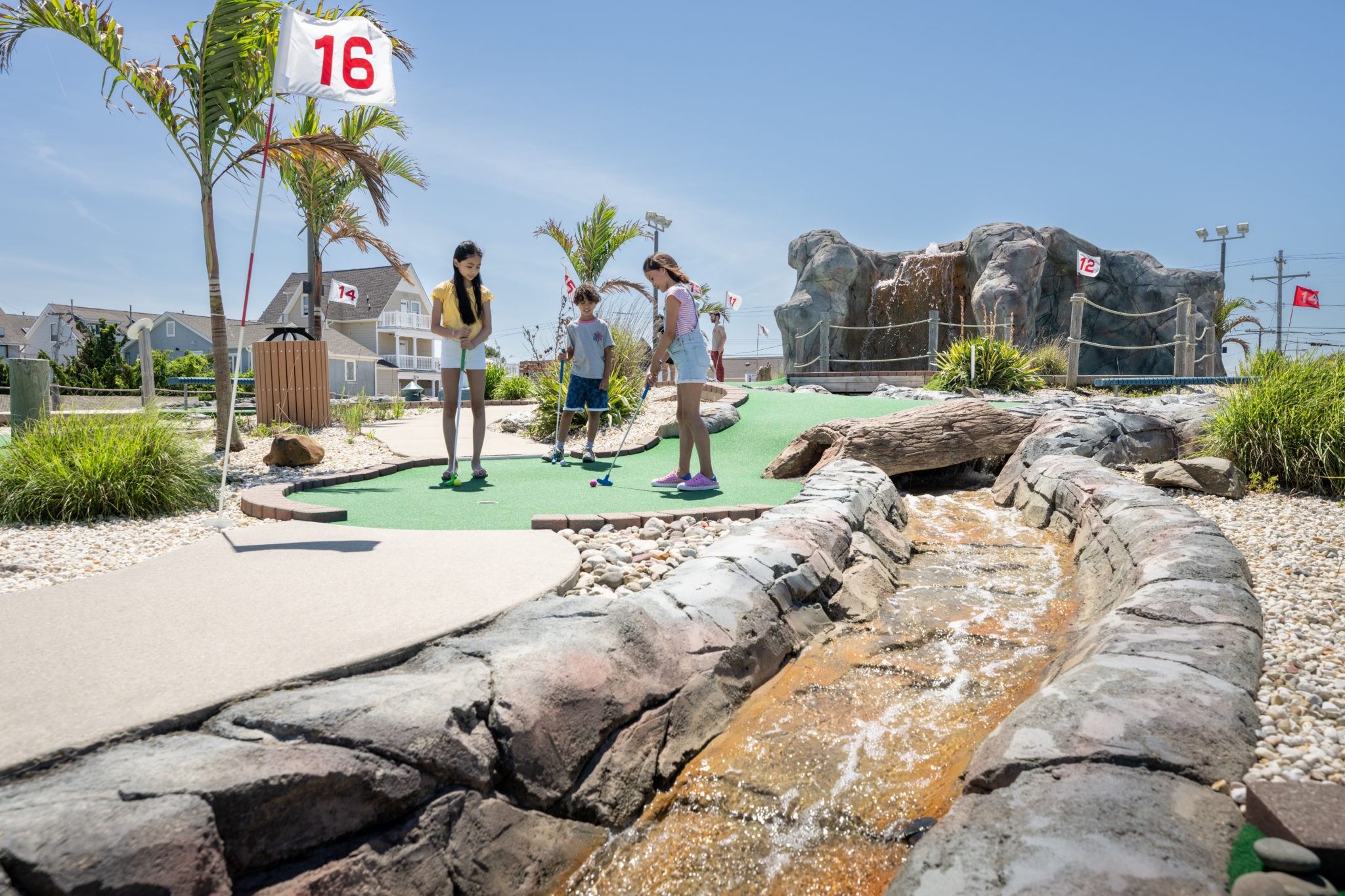 Two girls and a boy enjoy a round of golf at Lighthouse Point at Jenkinson's Boardwalk