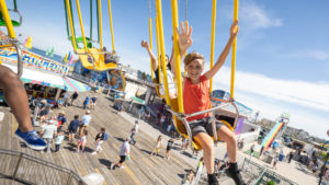 Riders enjoy Wave Swinger ride at Jenkinson's Boardwalk. Visitors pass through boardwalk